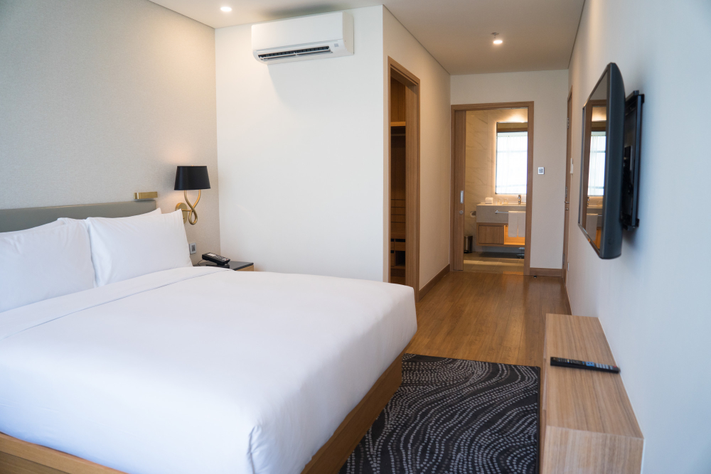 small hotel room interior with double bed bathroom 1